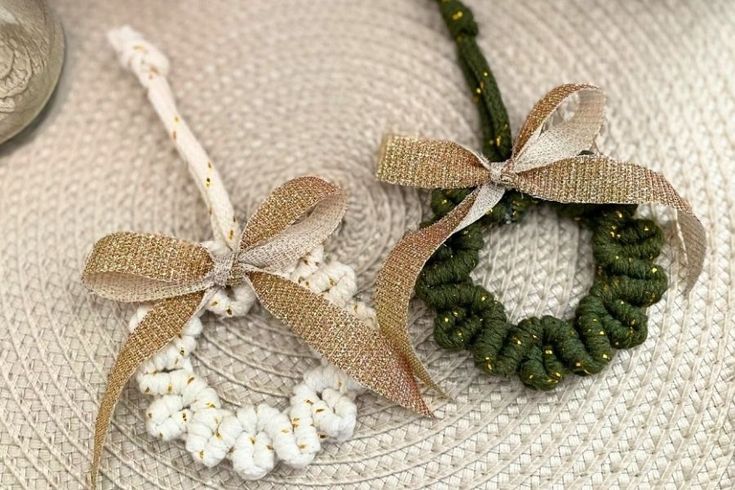 two wreaths are sitting on a table next to a silver spoon and some beads