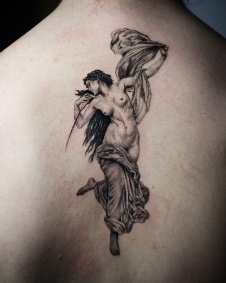 the back of a woman's shoulder with a tattoo on it