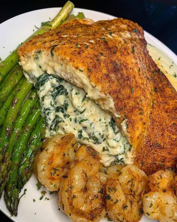 a white plate topped with fish and asparagus