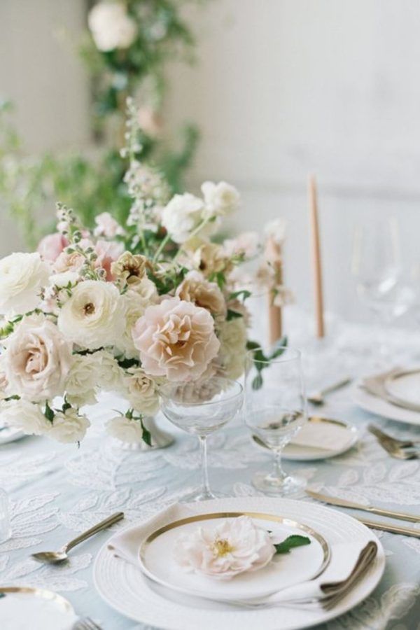 the table is set with white and pink flowers