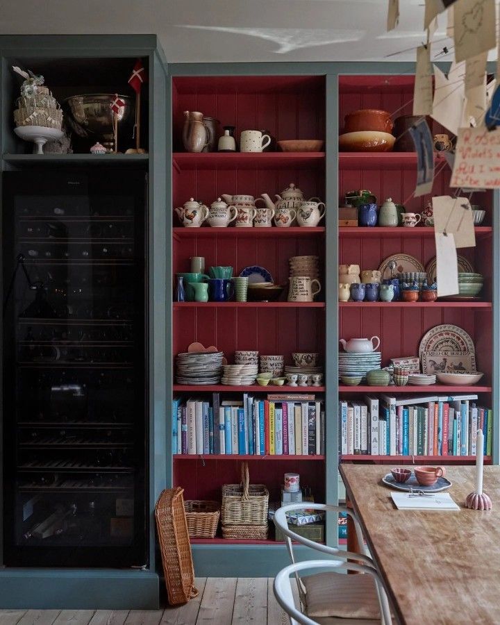 the shelves in this kitchen are filled with dishes and cups, along with bookshelves