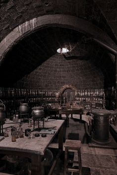 an old wine cellar with lots of bottles on the walls and tables in front of it