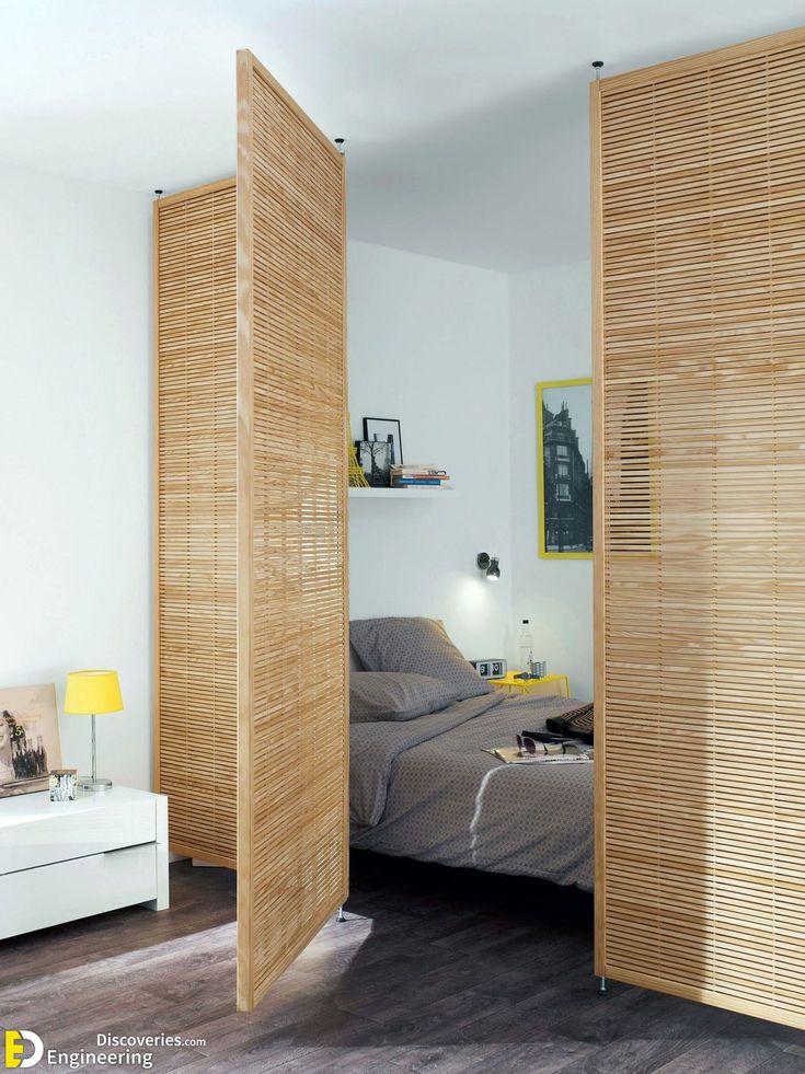 a bedroom with wooden slats on the walls and a bed in the corner between two doors