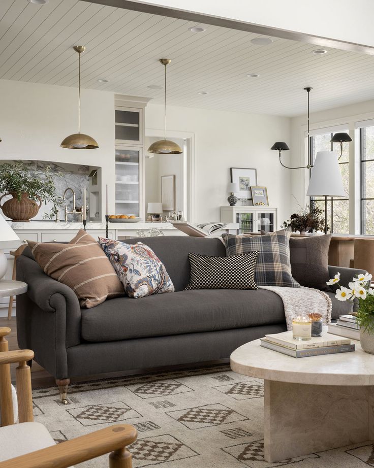 a living room filled with furniture and lots of pillows on top of the couches