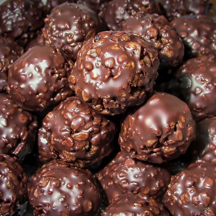 chocolate covered donuts are piled on top of each other