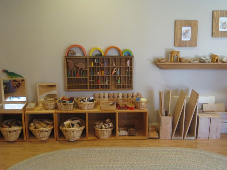 a room filled with lots of crafting supplies and wooden shelves on the wall next to a rug