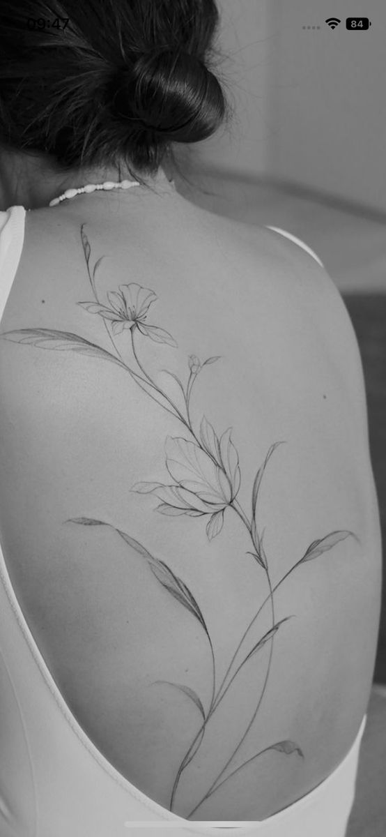 the back of a woman's shoulder with flowers on it