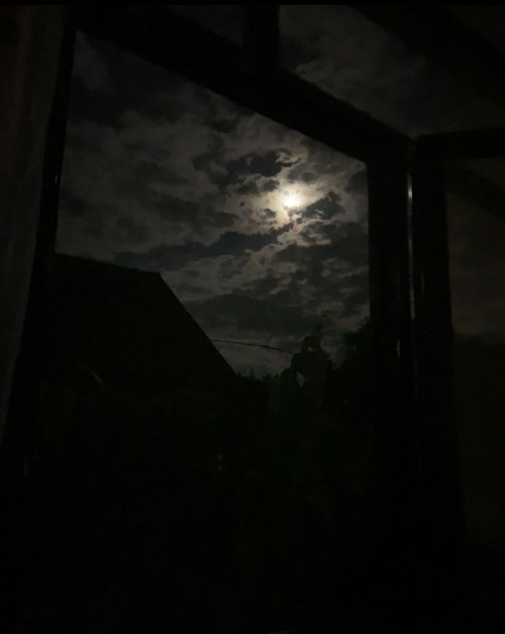 the full moon is seen through an open window