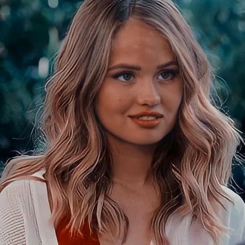 a close up of a person with long hair and an orange lipstick on her lips