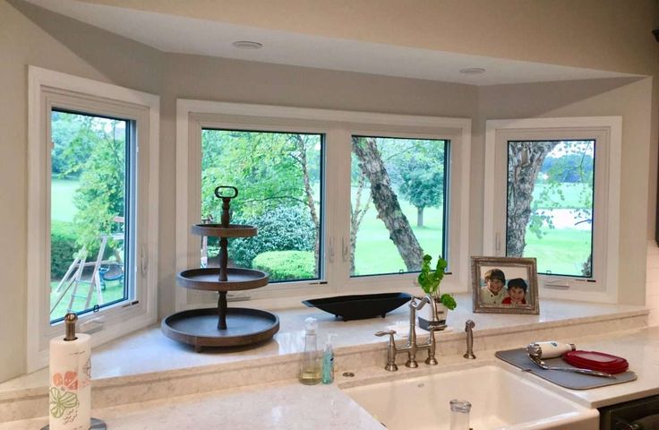 a kitchen with three windows and a sink