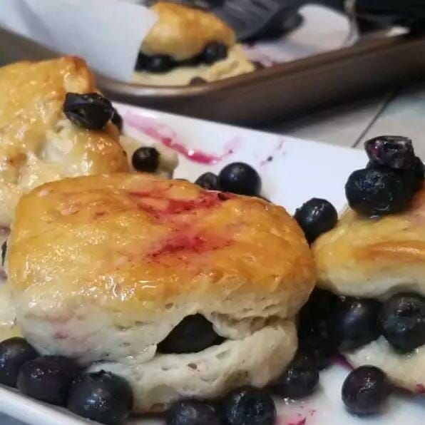 some blueberries and biscuits are on a white plate