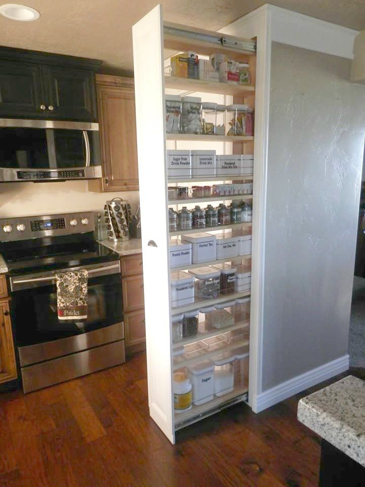 an open pantry door in a kitchen with stainless steel appliances