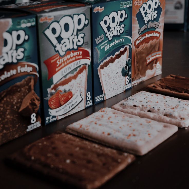 three boxes of pop tarts are sitting on a table with crackers and ice cream