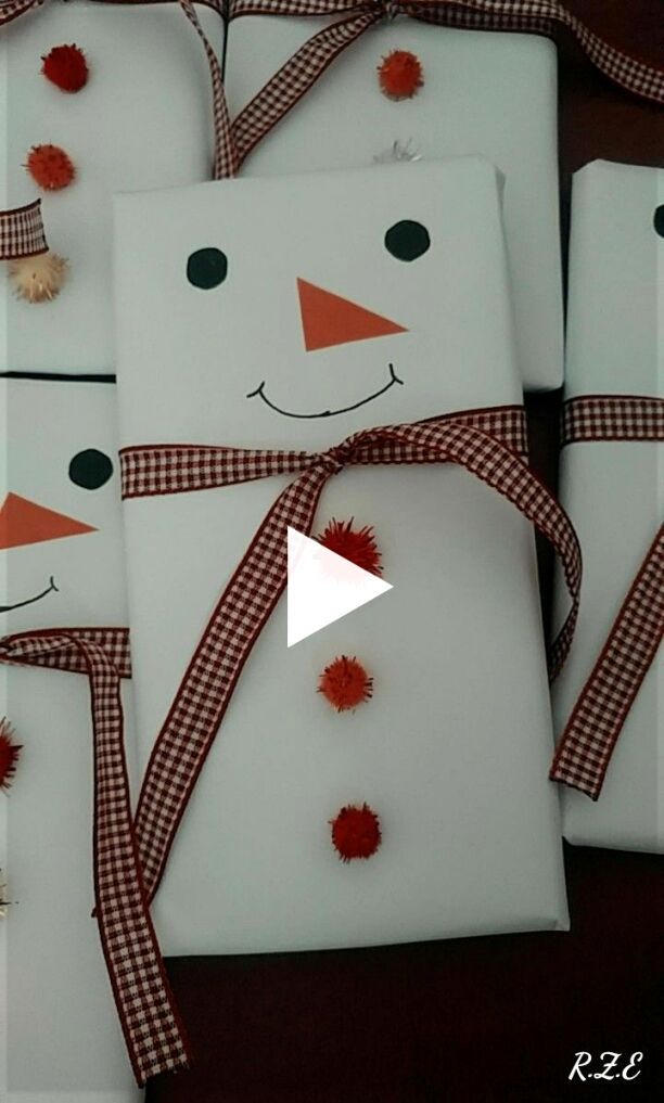 snowmen are wrapped in white paper and tied with red ribbon