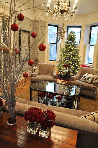 a living room filled with lots of furniture and christmas tree in the middle of it