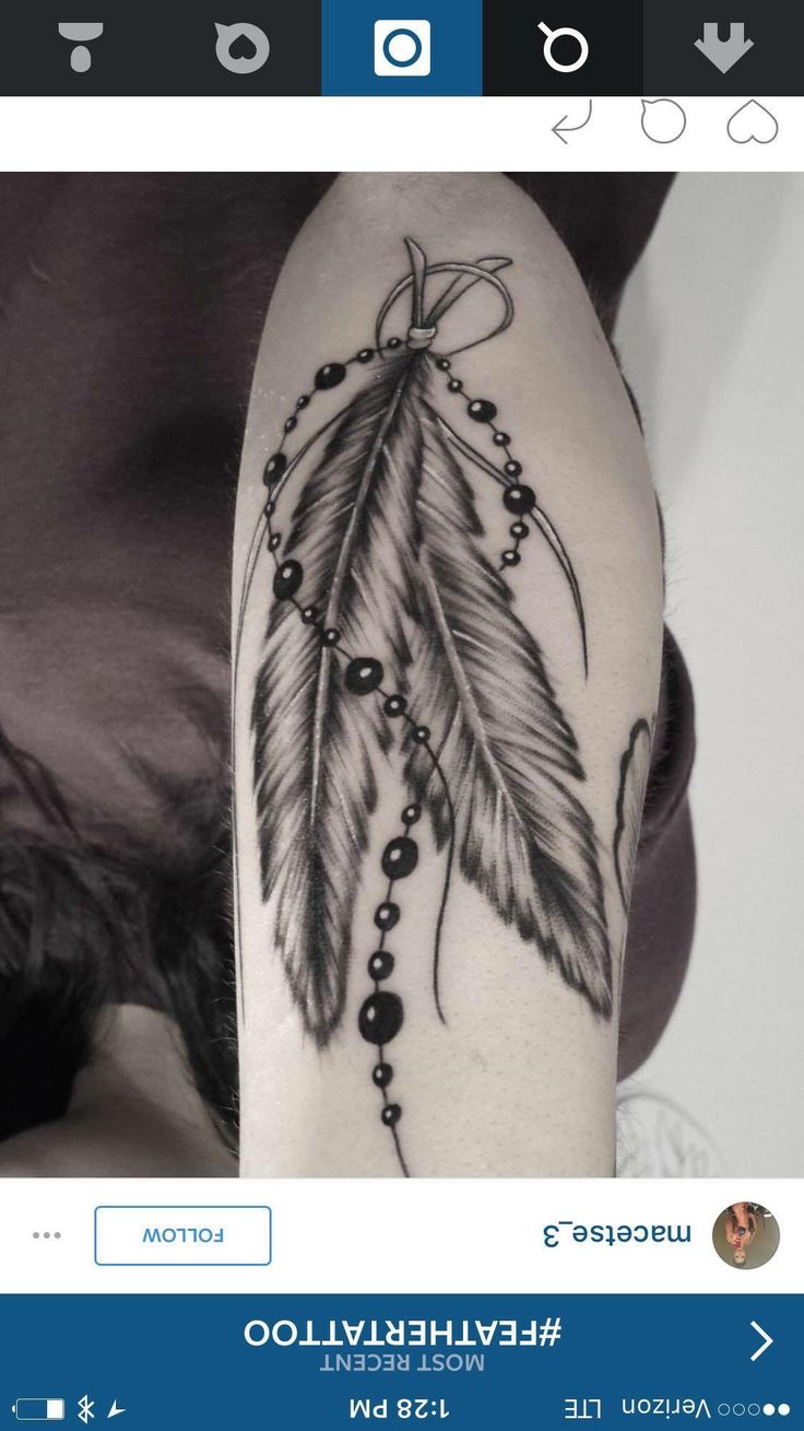 a woman's arm with a feather and beads tattoo on it