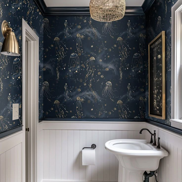 the bathroom is decorated in blue and white with gold decorations on the wall, along with a pedestal sink