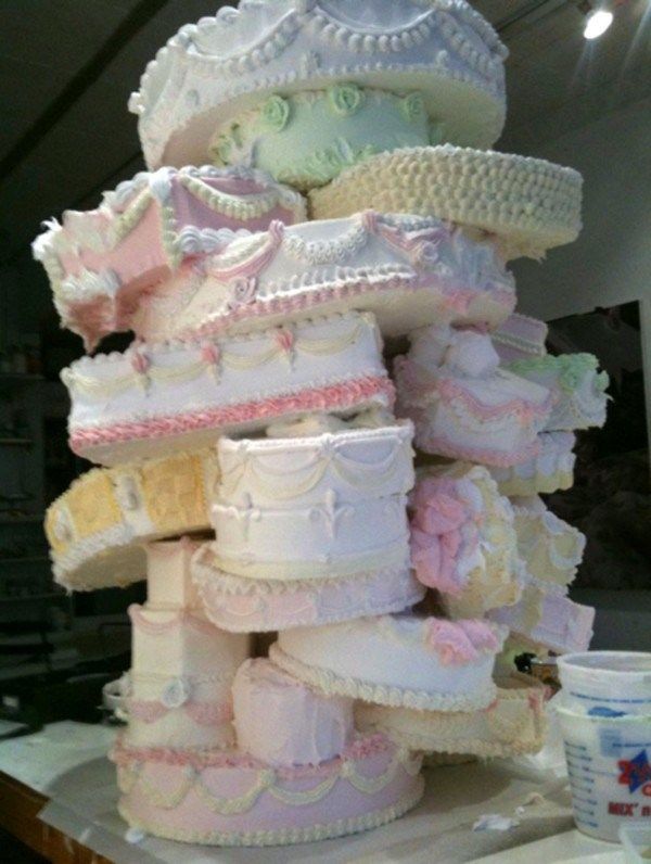 a large stack of baby shower cakes sitting on top of a counter next to a cup