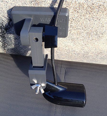 a close up of a street light on the side of a building with a power cord attached to it