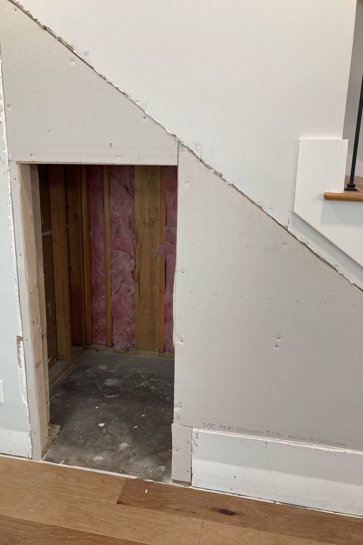 an unfinished room with wood flooring and white walls