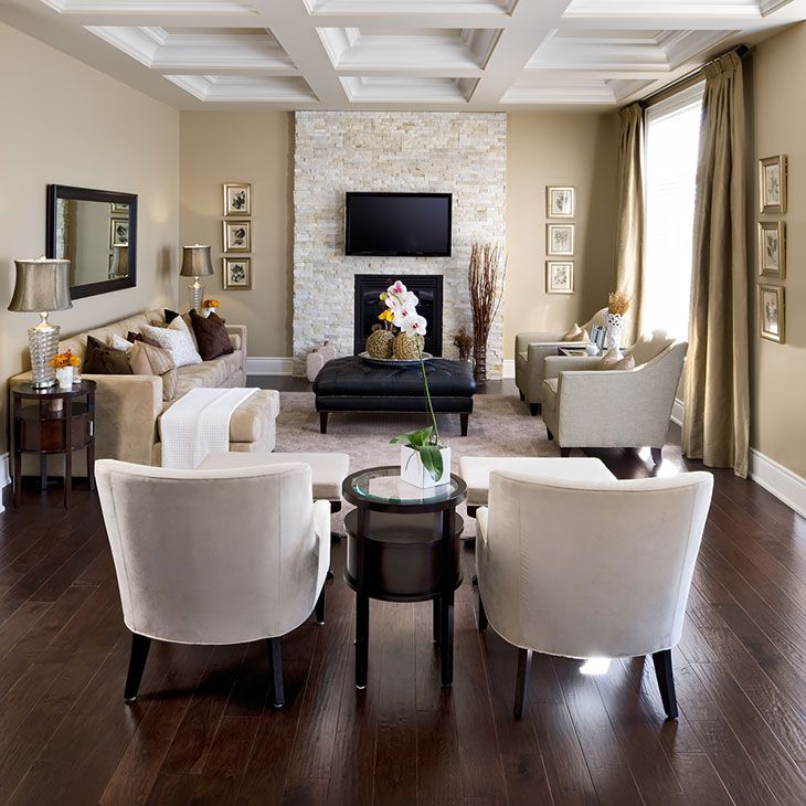 a living room filled with furniture and a flat screen tv mounted on the wall over a fireplace