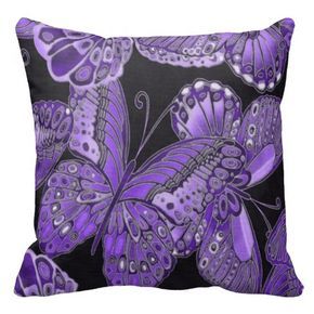 a pink and black pillow with butterflies on it