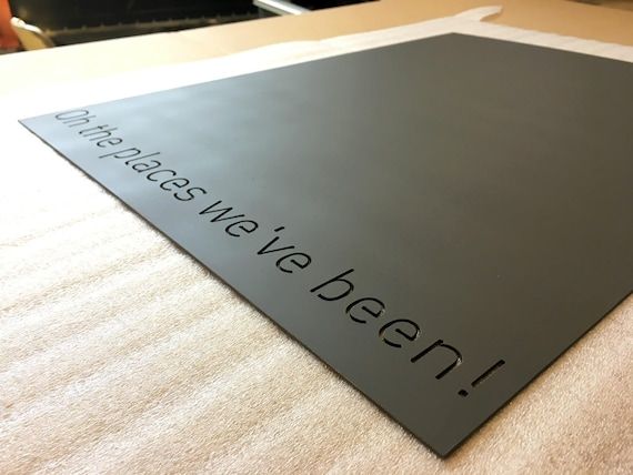 a close up of a black sign on a table with a person in the background