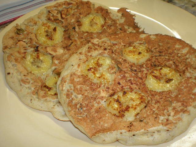 two pancakes on a plate with bananas and other toppings