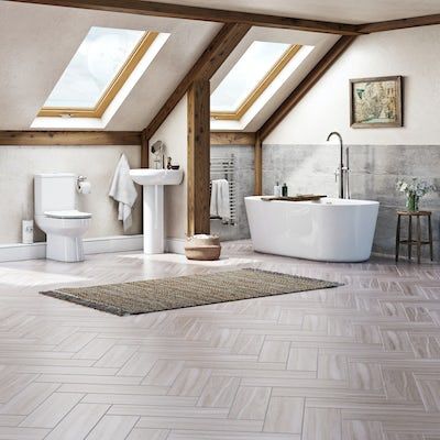 an attic bathroom with skylights and a white bathtub in the middle of it