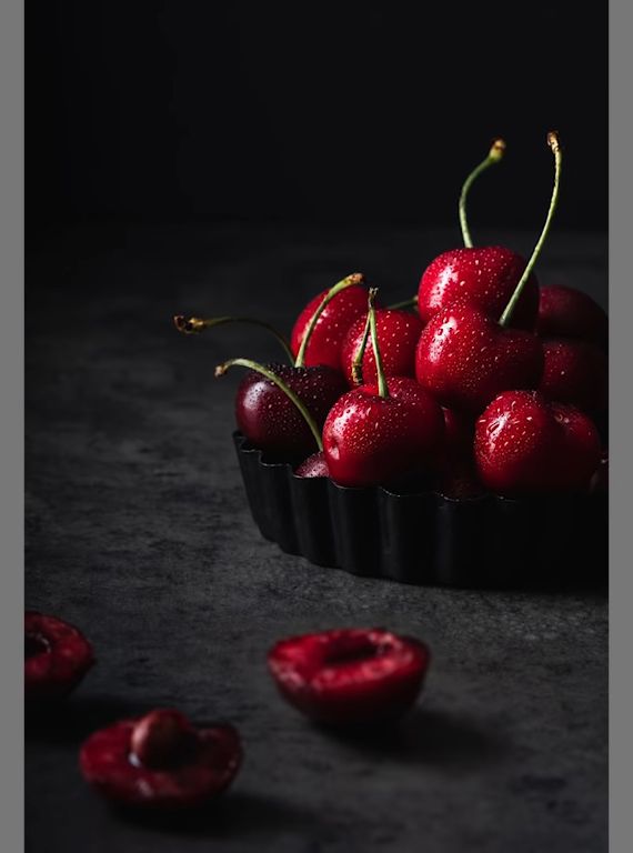 some cherries are sitting in a black bowl