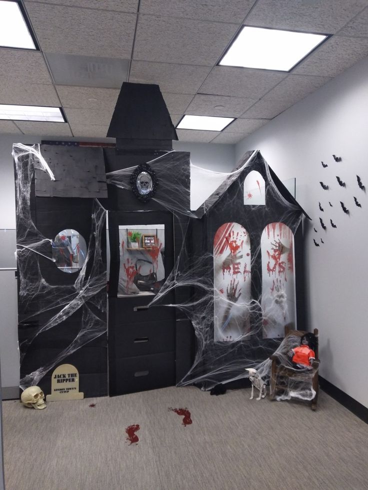 an office decorated for halloween with black and white decorations on the door, walls and floor