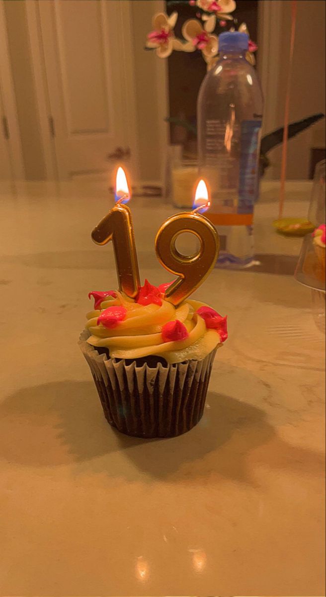 a cupcake with two candles sitting on a table