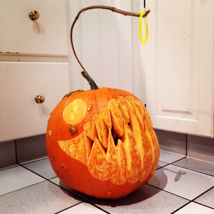 a carved pumpkin sitting on top of a kitchen floor