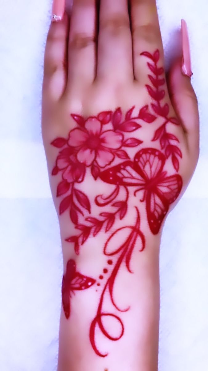 a woman's hand with red flowers on it