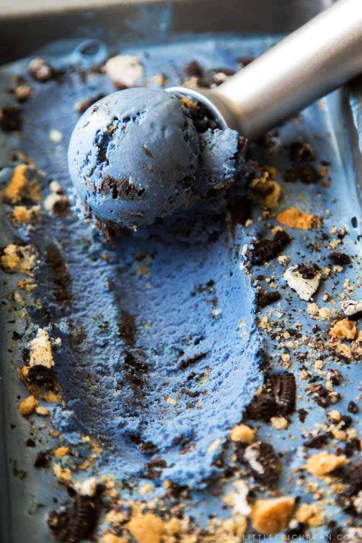 a scoop of ice cream with chocolate chips and cookies on it in a metal pan