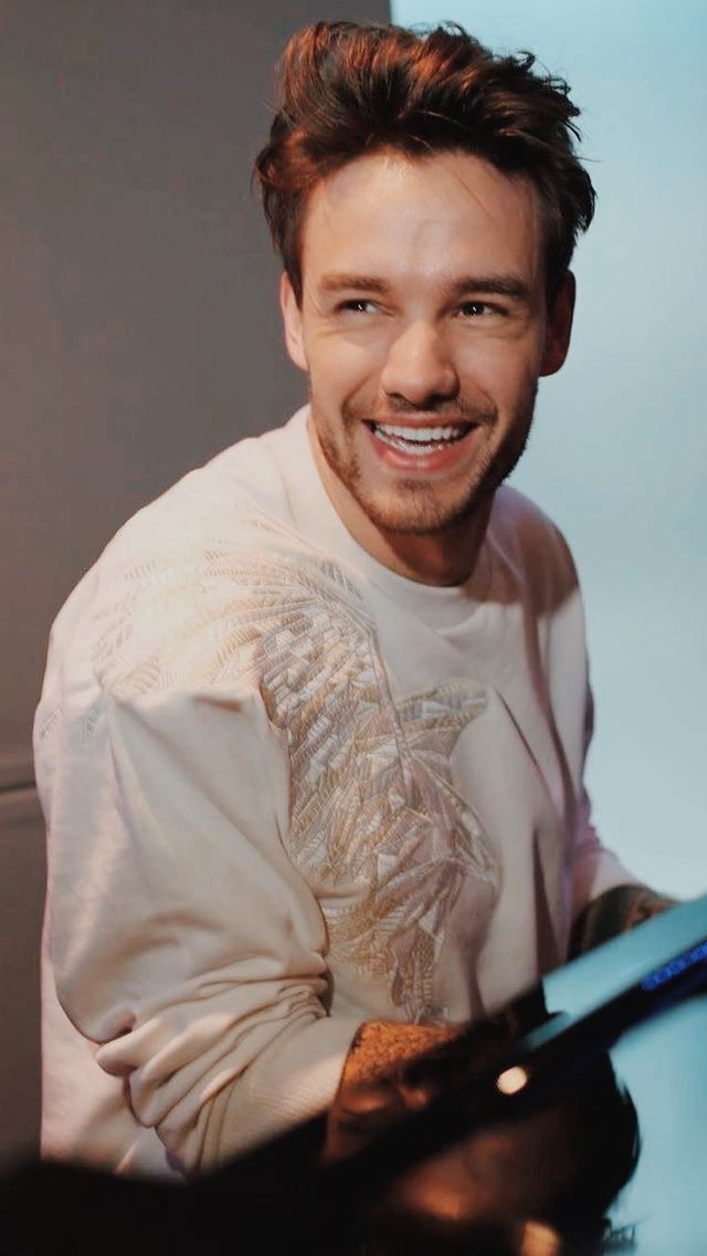 a man sitting at a desk smiling for the camera