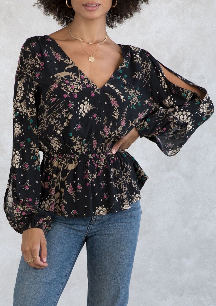 With bohemian details throughout, this flattering peplum blouse is a go-to style for the season. Designed in an autumnal wildflower print, featuring long voluminous split sleeves, a sexy open back with tassel tie closure, and a v-neckline. FINAL SALE Wildflower print Relaxed fit Long voluminous split sleeve Elastic wrist cuff Elastic peplum waist V-neckline Open back with tassel tie closure Dreamy bohemian blouse Model is 5'8, wearing a size S.Style: I-13716W-ROR-CD Fall Peplum Top For Brunch, Chic V-neck Peplum Top For Fall, Chic Long Sleeve Peplum Top For Brunch, Spring Floral Print Bell Sleeve Blouse, Floral Print Lantern Sleeve Tops For Brunch, Floral Lantern Sleeve Tops For Brunch, Black Long Sleeve Top With Boho Print, Spring Black Boho Print Tops, Black Boho Print Tops For Spring