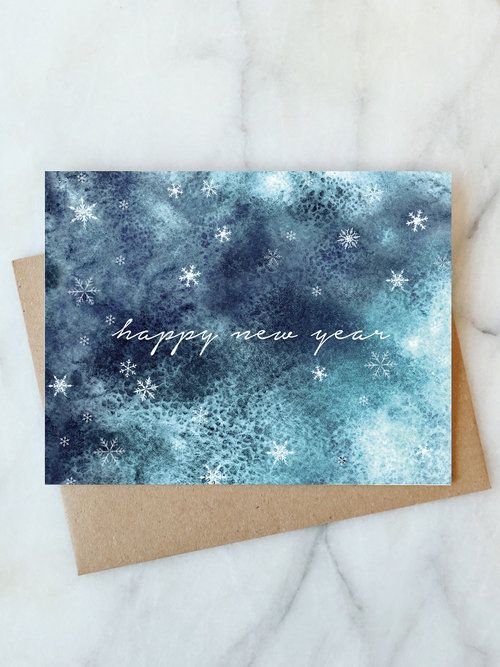 a card with the words happy new year written in white ink on a blue background