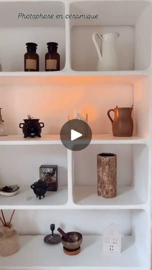 a white shelf filled with vases and other items on top of it's shelves