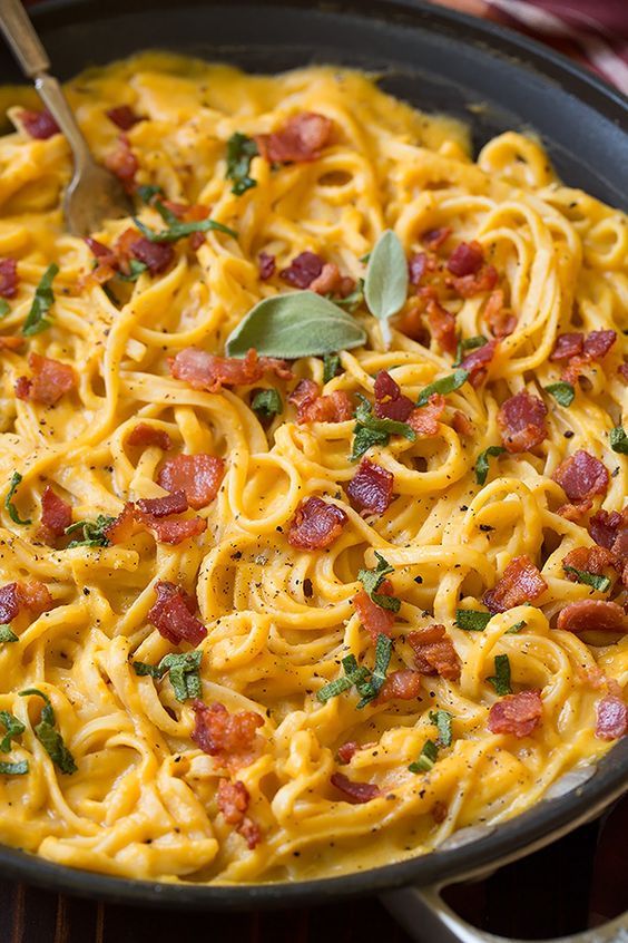 a pan filled with pasta and topped with bacon