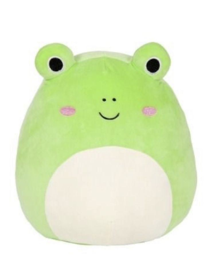 a green frog pillow with eyes and nose on it's face, sitting against a white background