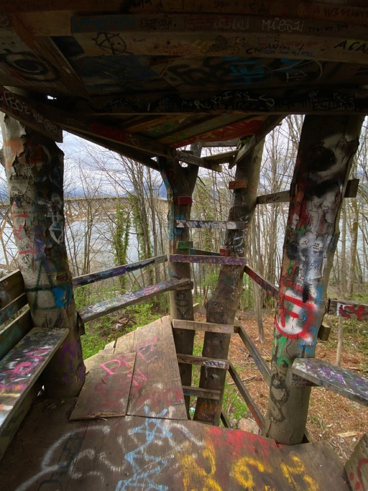 an old wooden bench covered in graffiti