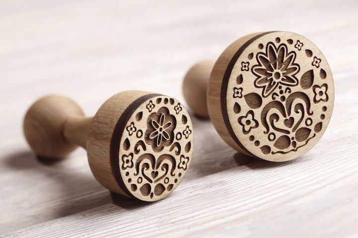 two wooden knobs with designs on them sitting next to each other in front of a white background