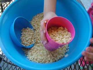 a child pouring rice into a blue bowl