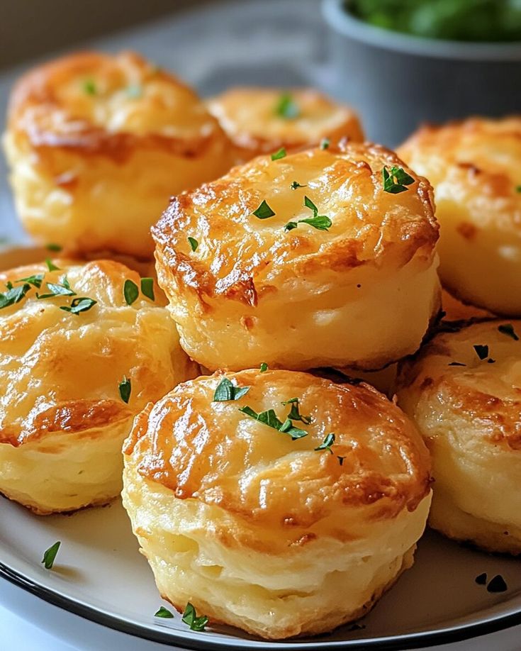 several small pastries on a white plate with green garnish and parsley