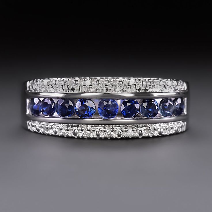 a blue and white diamond ring on a black surface with diamonds around the band, set in 18k white gold