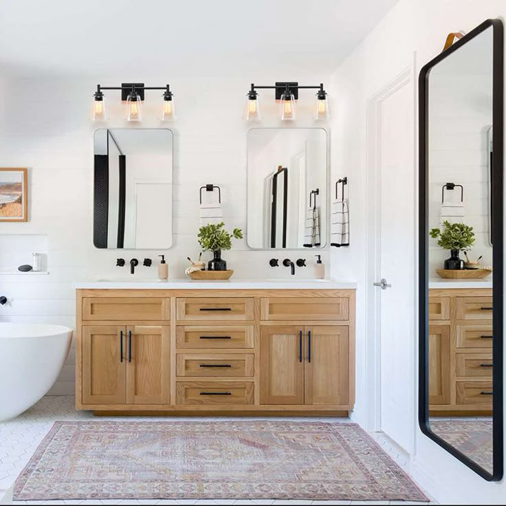 a bathroom with two sinks, mirrors and a bathtub in the middle of it