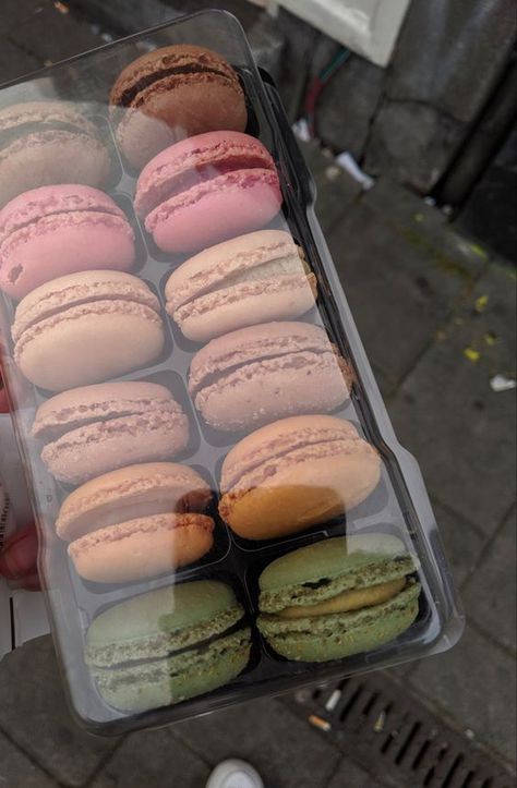 a plastic container filled with lots of different colored macaroons