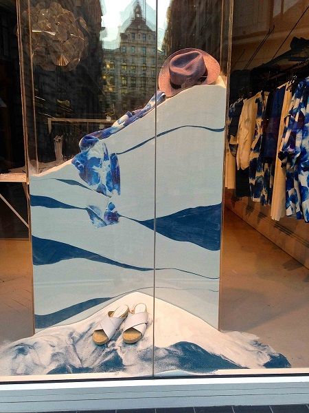 there is a display in the window of a clothing store that has blue and white designs on it