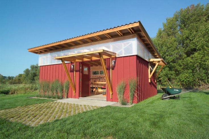 a small red shed sitting on top of a lush green field